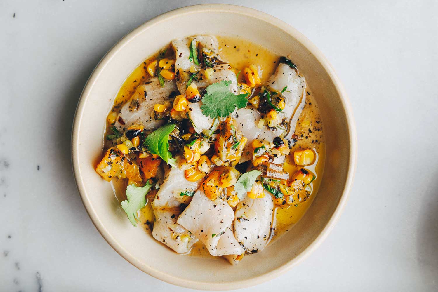 White fish ceviche with charred corn and coriander leaf