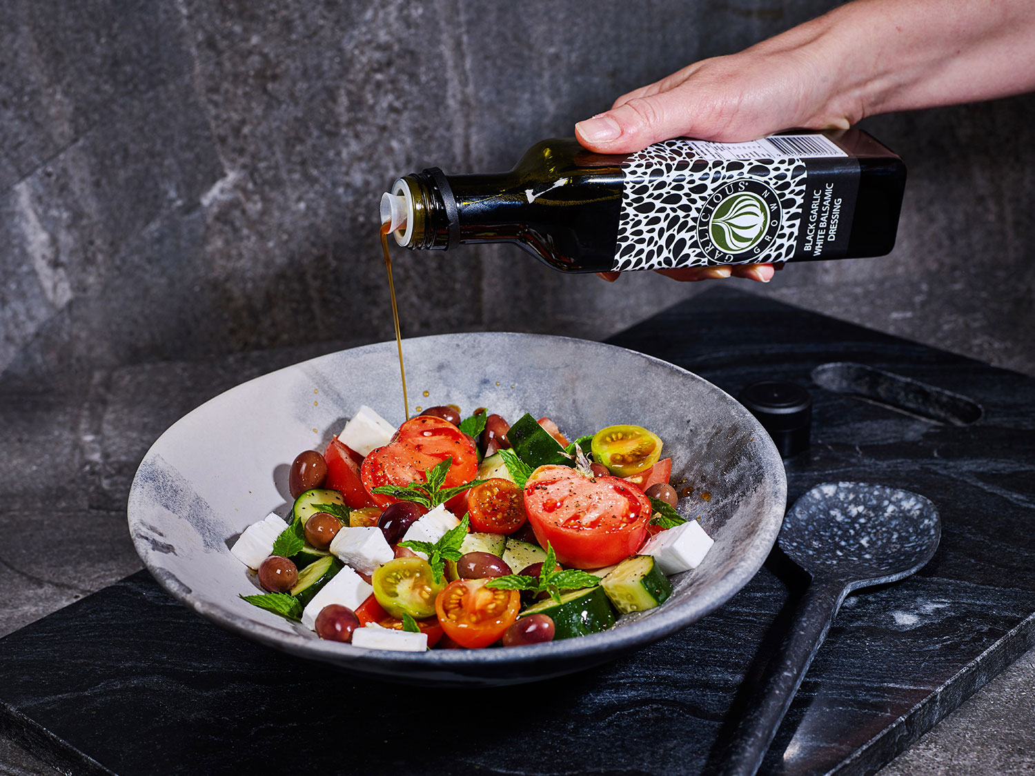 Vegan Greek Salad with a mix of heirloom and cherry tomatoes, vegan feta and Black Garlic White Balsamic Dressing